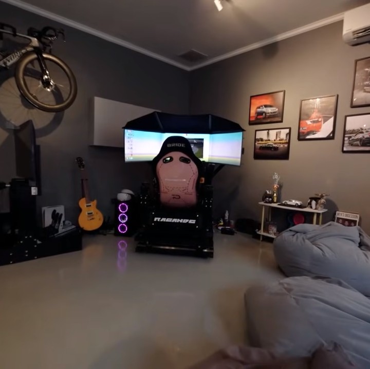 <p>Sangun Regahdo dan istri mendesain satu ruangan khusus untuk bersantai di dalam rumah. Di ruangan ini, keduanya meletakkan peralatan <em>gaming</em> yang lengkap dengan beberapa <em>frame</em> foto mobil balap. (Foto: YouTube AH)</p>