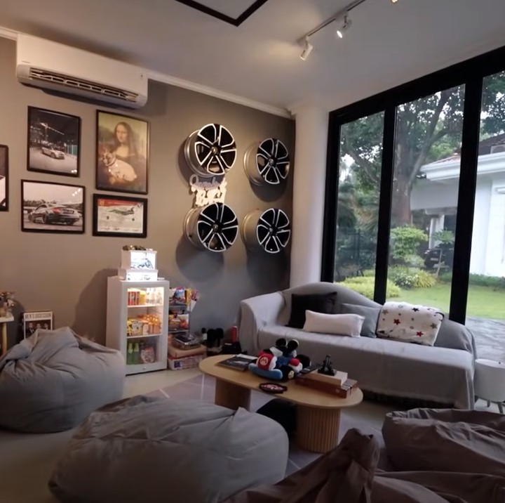 <p>Di ruangan ini, Sangun Regahdo juga membuat area bersantai di mana ia meletakkan sofa dan beberapa <em>bean bag</em>. Ruangan khusus <em>gaming</em> ini dikelilingi jendela besar yang menghadap ke taman luar rumah. (Foto: YouTube AH)</p>