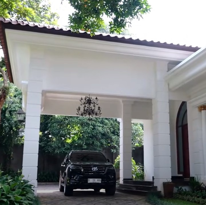 <p>Rumah bergaya modern milik Sangun Regahdo ini dikelilingi taman yang luas, Bunda. Ada pepohonan rindang di dekat pintu masuk utama rumah. (Foto: YouTube AH)</p>