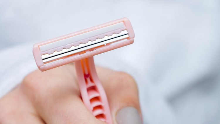 Ilustrasi alat cukur bulu A lady's shaver in female hand. Close-up, selective focus.