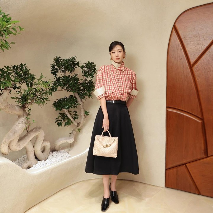 <p>Kim Dami diketahui kerap menghadiri acara fashion show Bottega Veneta. Dalam foto ini, artis Korea berusia 30 tahun tersebut mengenakan A-line skirt berwarna hitam yang dipadu dengan atasan plaid merah. (Foto: Instagram @d_a___m_i)</p>