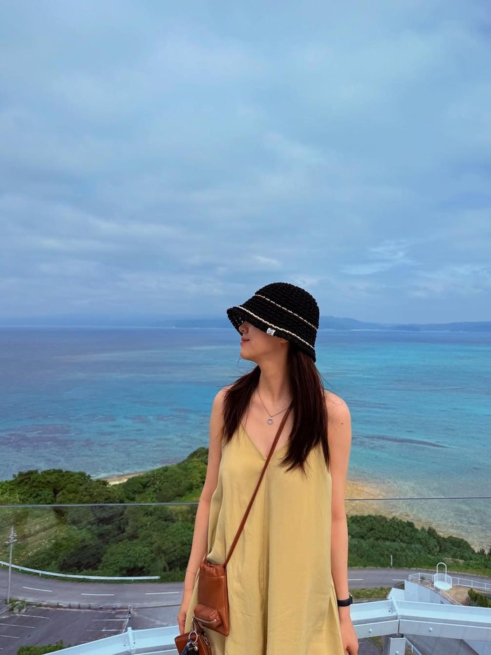 Penampilan cantik effortless Kim Ji Eun dalam balutan loose dress, sling bag cokelat, dan bucket hat hitam saat liburan di Bali sukses memesona dan juga bisa disontek. Nyaman, bebas gerak, namun tetap anggun dan modis./ Foto: instagram.com/kj_ieun