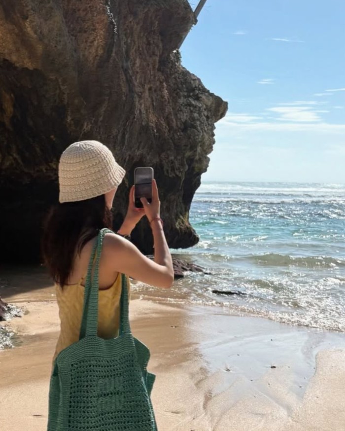 Selain itu, Kim Ji Eun juga merasakan sensasi hangat dari halusnya pasir putih, tak lupa turut mengabadikan pemandangan pantai luas membentang dengan gelombang airnya yang berkilauan memercikkan cahaya mentari./ Foto: instagram.com/kj_ieun