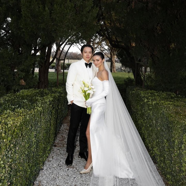 <p>Perempuan 24 tahun ini terlihat menawan mengenakan gaun pengantin berwarna putih yang terlihat begitu annggun dan memberikan kesan elegan. Sementara sang suami, tuxedo berwarna putih.  (Foto: Instagram@amandarawles)</p>