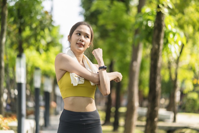 asian cheerful young adult Attractive and strong morning stretching before runin the park Sports concept. Healthy lifestyle Young fitness woman runner stretching before run on The park