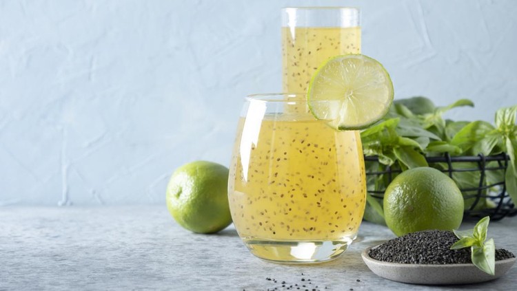 Minuman chia seed Basil seed drink with orange juice in glass on light background. Close up. Healthy detox beverage for lose weight. Space for text.
