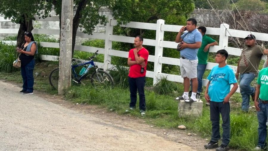 Orang-orang mengamati saat pihak berwenang bekerja di area kecelakaan.