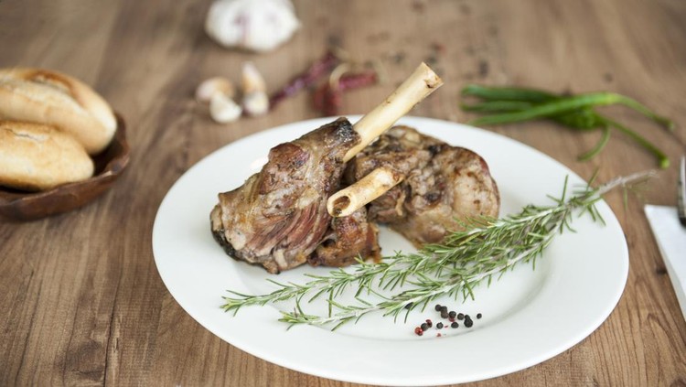 Roast Leg of Lamb on the plate on wooden table