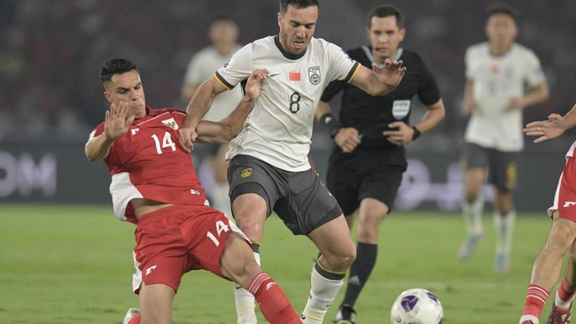 Pesepak bola Timnas Indonesia Joey Pelupessy (kiri) berebut bola dengan pesepak bola Timnas China Sai Erjiniao (tengah) pada pertandingan Kualifikasi Piala Dunia 2026 putaran ketiga Grup C di Stadion Utama Gelora Bung Karno, Jakarta, Kamis (5/6/2025)