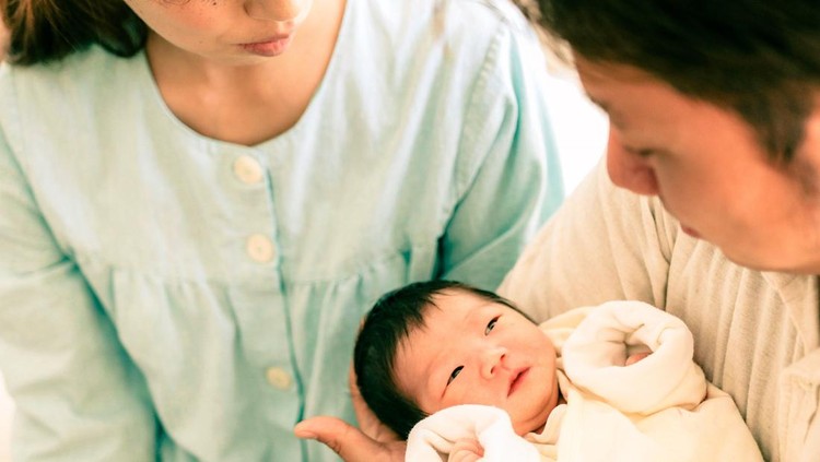 Ilustrasi melahirkan Japanese parents looking their newborn baby at the hospital