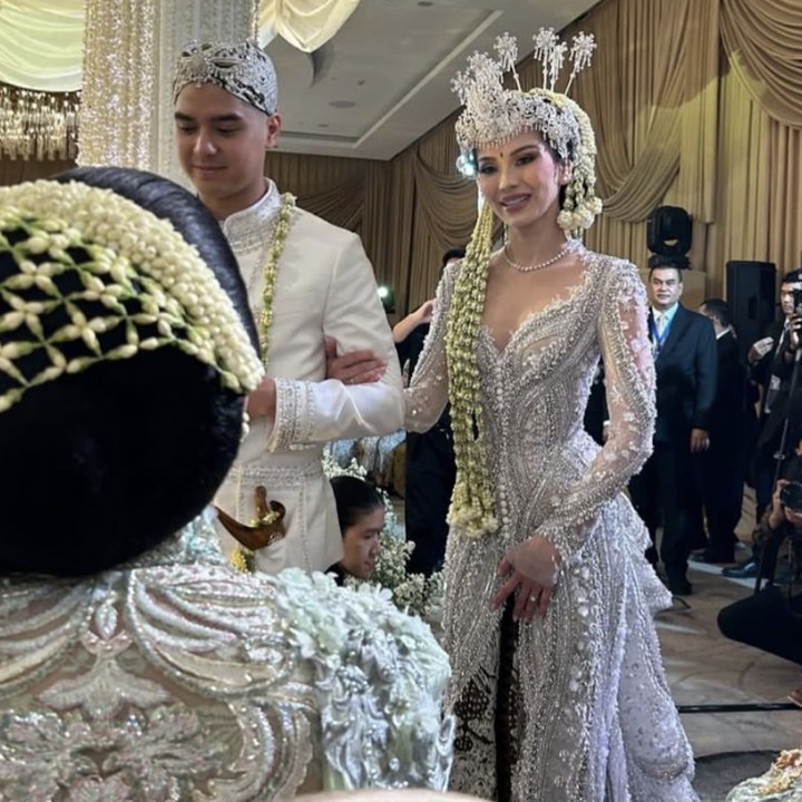 <p>Penampilan Alyssa tak kalah memukau. Perempuan keturunan Prancis ini mengenakan pakaian adat Sunda berwarna putih dengan hiasan payet perak. Alyssa menyempurnakan penampilannya dengan mengenakan siger Sunda dan ronce bunga sebagai hiasan di kepalanya. (Foto: Instagram @pinkyevianty)</p>
