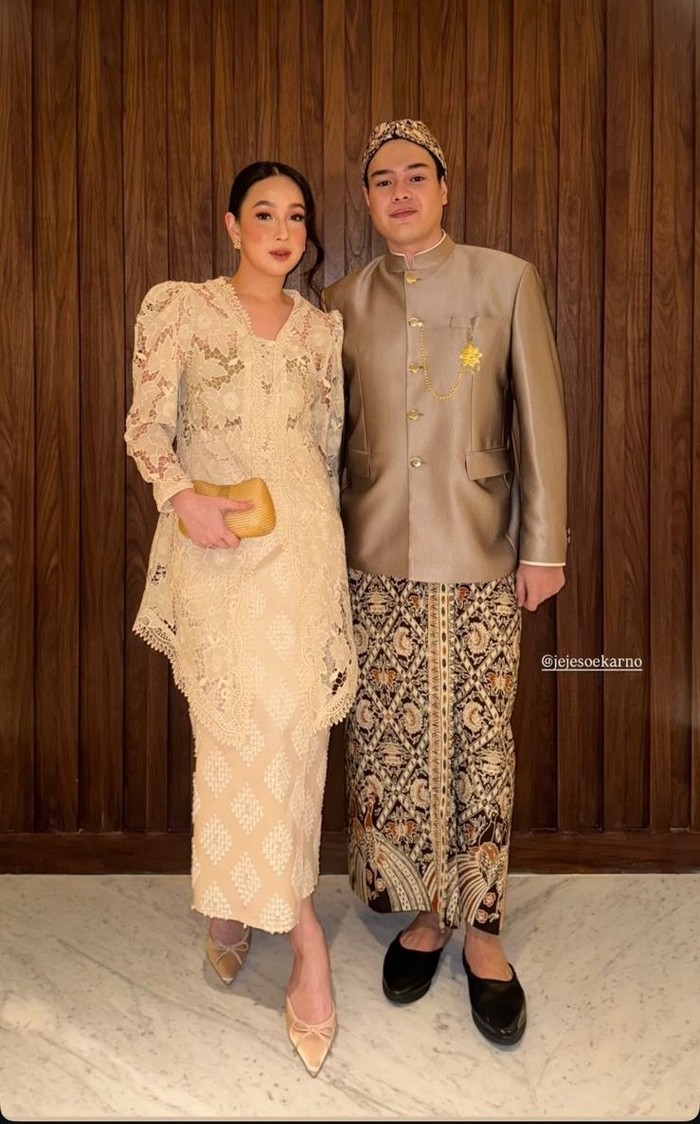 Pricilla tampil anggun dalam kebaya brokat krem dengan sentuhan klasik dan clutch emas. Sementara, Jeje Soekarno tampil gagah dalam beskap abu-abu dan jarik motif parang. (Pricilla/Foto: instagram.com/agthpricilla)