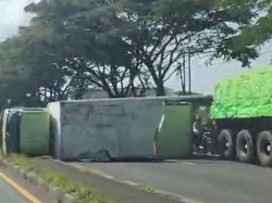 Truk Boks Muat Es Kristal Pecah Ban Lalu Terguling di Lamongan