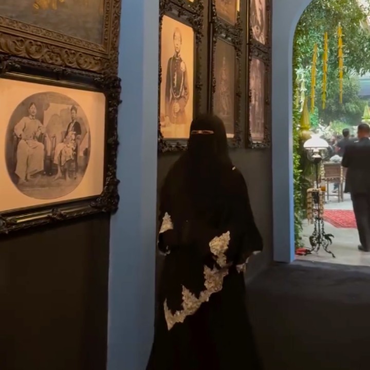 <p>Al Ghazali dan Alyssa banyak menggunakan dekorasi Jawa klasik di acara ngunduh mantu. Salah satu yang mencuri perhatian adalah lorong masuk ke tempat acara yang dipenuhi foto-foto rasa Jawa. Ustazah Umi Pipik sempat membagikan suasana lorong ini di akun Instagram miliknya. "Mabruk pak de @ahmaddhaniofficial konsepnya keren jawa banget aku yg orang jawa seneng liatnya, tamunya banyak bgt , makanan berlimpah, pokoknya doa terbaik utk semuanya ya," tulis Umi Pipik. (Foto: Instagram @_ummi_pipik_)</p>