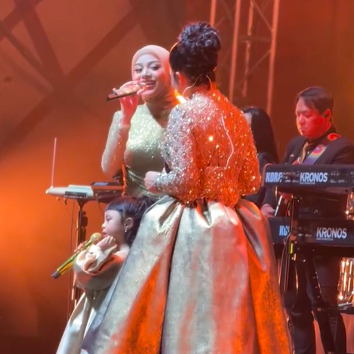 <p>Aurel dan putrinya Ameena kompak mengenakan baju berwarna keemasan. Ibu dan anak ini ikut menyumbangkan suara di atas panggung konser Krisdayanti. Dalam satu momen, Krisdayanti terlihat begitu bahagia saat menatap sang putri dan cucunya bernyanyi di hadapan penonton. (Foto: Instagram @aurelie.hermansyah)</p>