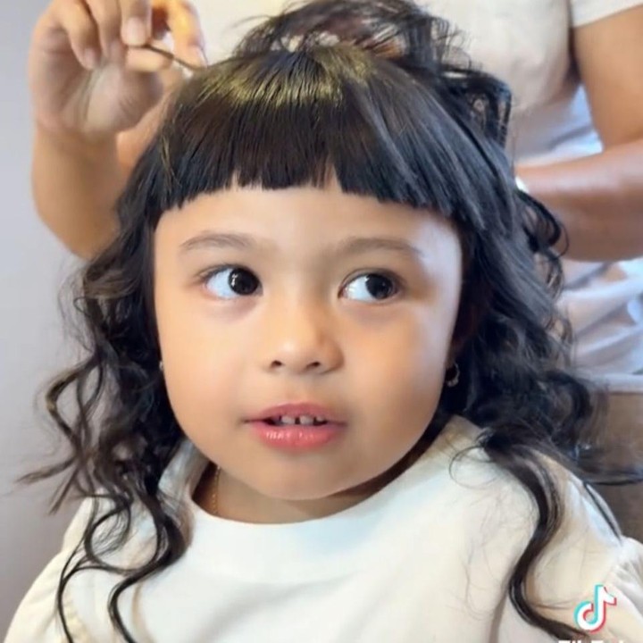 <p>Meski usianya masih tiga tahun, Ameena dapat menjelaskan proses pembuatan rambut curly yang tengah dilakukan oleh <em>hair stylist.</em> “Hai, lagi di-<em>curly</em> guys. Tadi udah pakai catokan sekarang di-wig,” ujar Ameena, dikutip dari laman <em>TikTok@aurelhermansyahatta,</em> Selasa (24/6/2025). (Foto: TikTok@aureliehermansyahatta)</p>