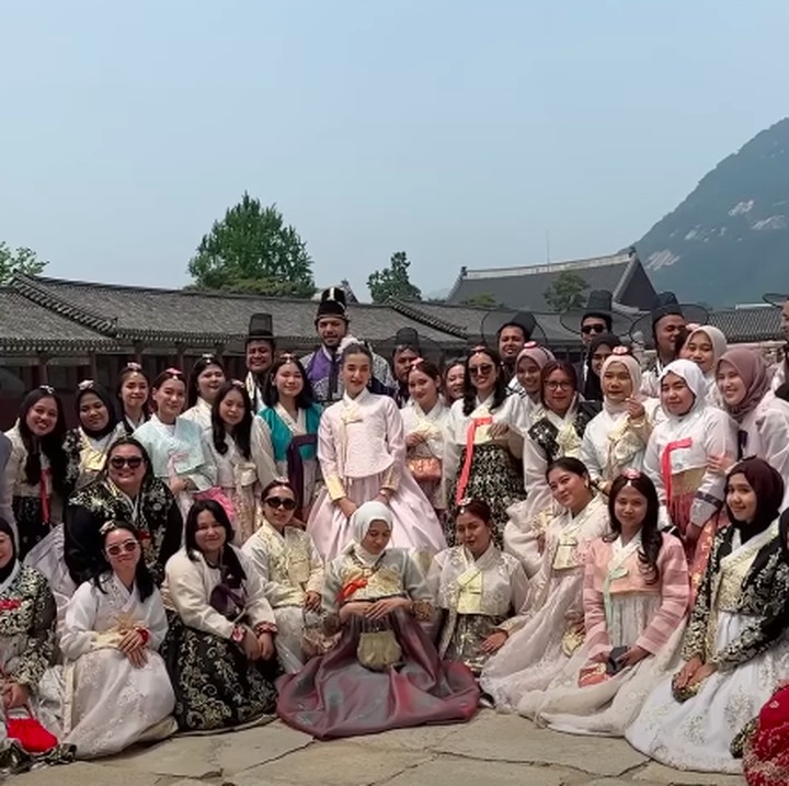 <p>Hari pertama, ia mengajak para karyawannya mengunjungi salah satu tempat populer di Korea yaitu Istana Gyeongbokgung. Mereka pun mengabadikan foto bersama dengan mengenakan baju tradisional Korea, hanbok. (Foto: YouTube tasya farasya)</p>