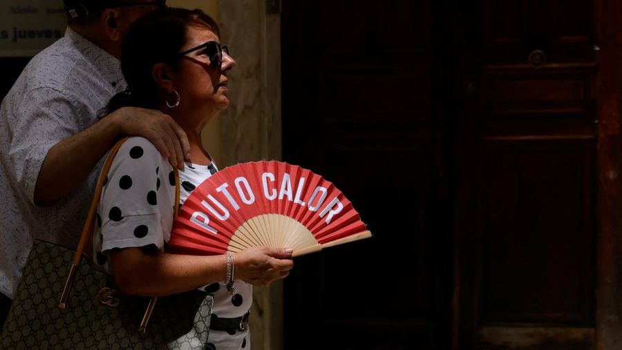 Turis melindungi diri dari terik mentari dengan payung selama gelombang panas musim panas pertama di Seville, Spanyol selatan, 29 Juni 2025. (REUTERS/Marcelo del Pozo)