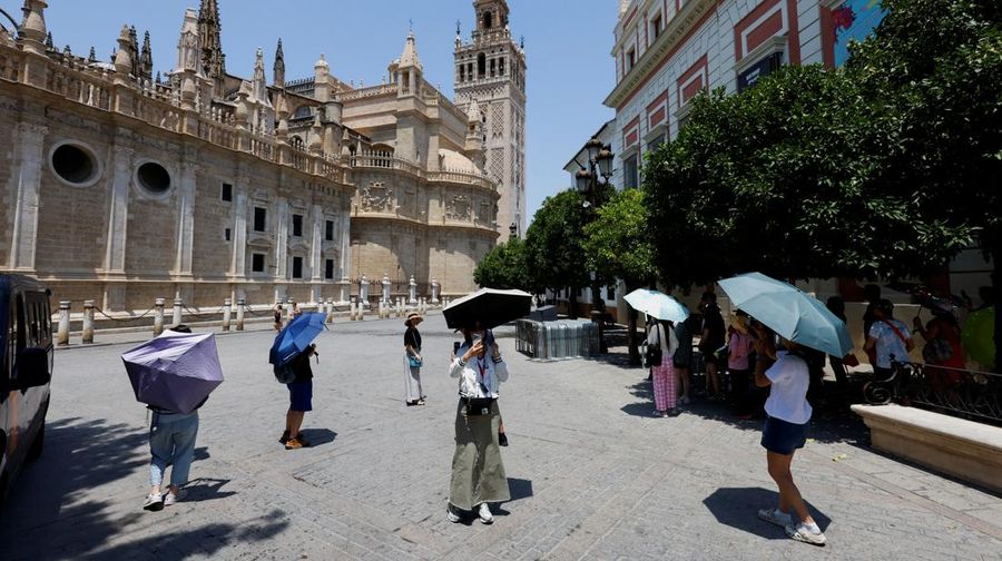 Turis melindungi diri dari terik mentari dengan payung selama gelombang panas musim panas pertama di Seville, Spanyol selatan, 29 Juni 2025. (REUTERS/Marcelo del Pozo)