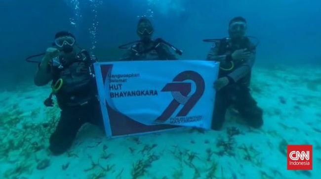 Personel Polsek Bontomanai menggelar upacara di bawah laut untuk merayakan HUT Bhayangkara ke-79.