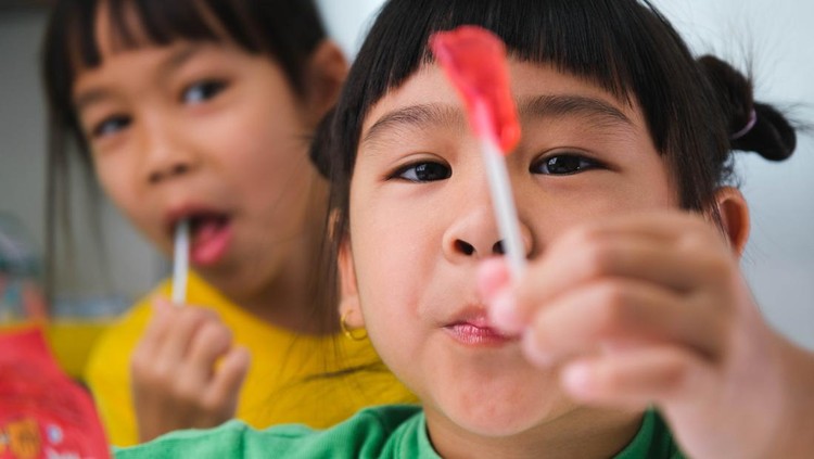 anak makan permen Cara Gula Merusak Otak Anak