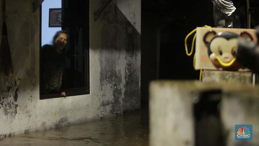 Sejumlah penduduk melintas di tengah banjir di RW 06 Jatipadang, Jakarta Selatan, (6/7/2025). (librosfullgratis.com/Muhammad Sabki)