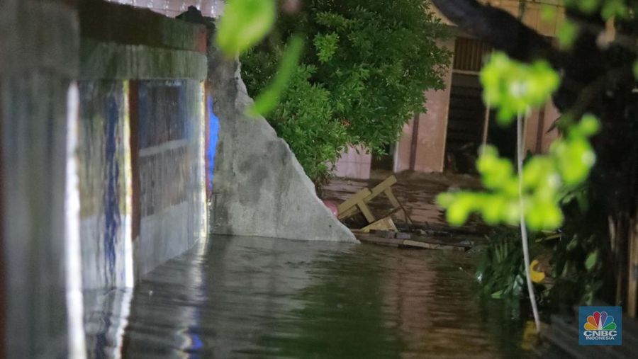 Sejumlah penduduk melintas di tengah banjir di RW 06 Jatipadang, Jakarta Selatan, (6/7/2025). (librosfullgratis.com/Muhammad Sabki)