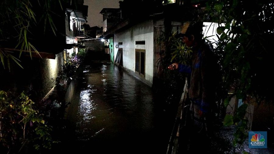 Sejumlah penduduk melintas di tengah banjir di RW 06 Jatipadang, Jakarta Selatan, (6/7/2025). (librosfullgratis.com/Muhammad Sabki)