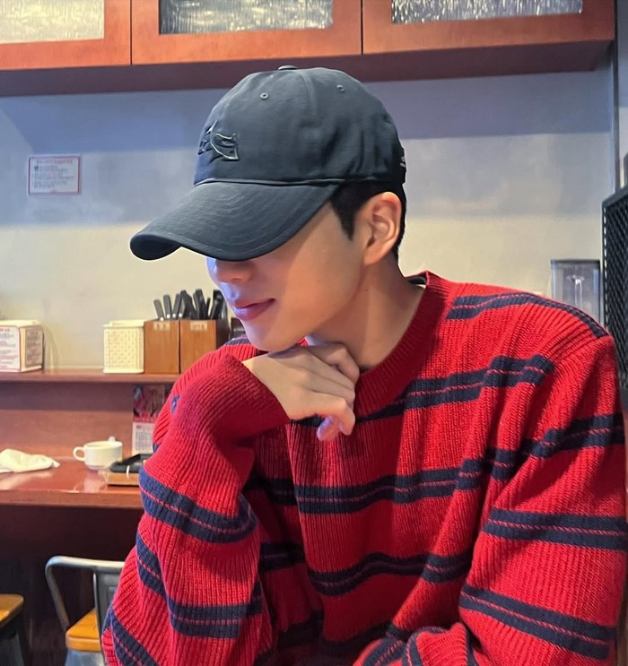 Hangout di cafe, ia terlihat chic dengan sweater rajut merah dengan aksen stripe yang ia padukan dengan topi biru/ Foto: Instagram.com/chakangyoon