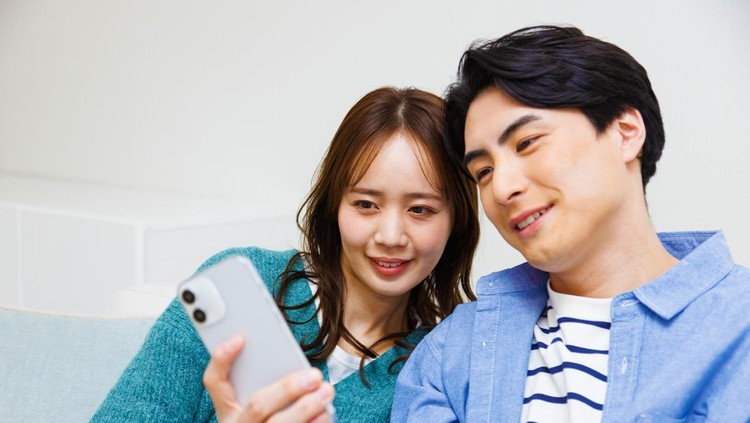 Japanese couple taking a self photograph with phone