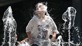 A child plays in a fountain to cool off in the central Gwanghwamun area of Seoul on July 10, 2025, as a heat wave warning has been issued by the South Korean government. More than a thousand people have been affected by heat-related illnesses in Sout