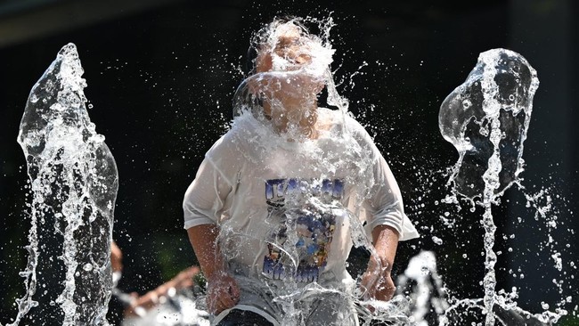 A child plays in a fountain to cool off in the central Gwanghwamun area of Seoul on July 10, 2025, as a heat wave warning has been issued by the South Korean government. More than a thousand people have been affected by heat-related illnesses in Sout