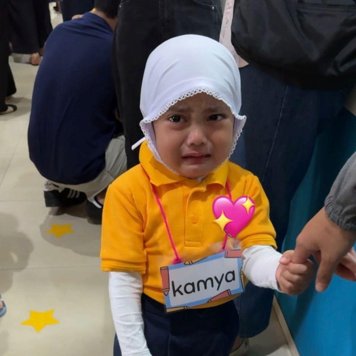 <p>Saat digandeng menuju kelas, Kamya tampak berusaha tegar meski wajahnya menyimpan rasa cemas. Momen itu pun diabadikan sang Bunda dengan penuh rasa haru. "Pas mau masuk kelas mulai berderai air mata," kata Fitri Tropica. Namun, perlahan Kamya sudah mulai beradaptasi dengan lingkungan barunya. (Foto: Instagram @fitrop)</p>