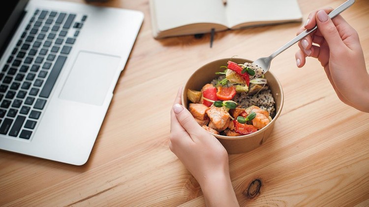 Ilustrasi diet sehat A woman has lunch and works at home. Close-up. Top view. Space for text in the smartphone