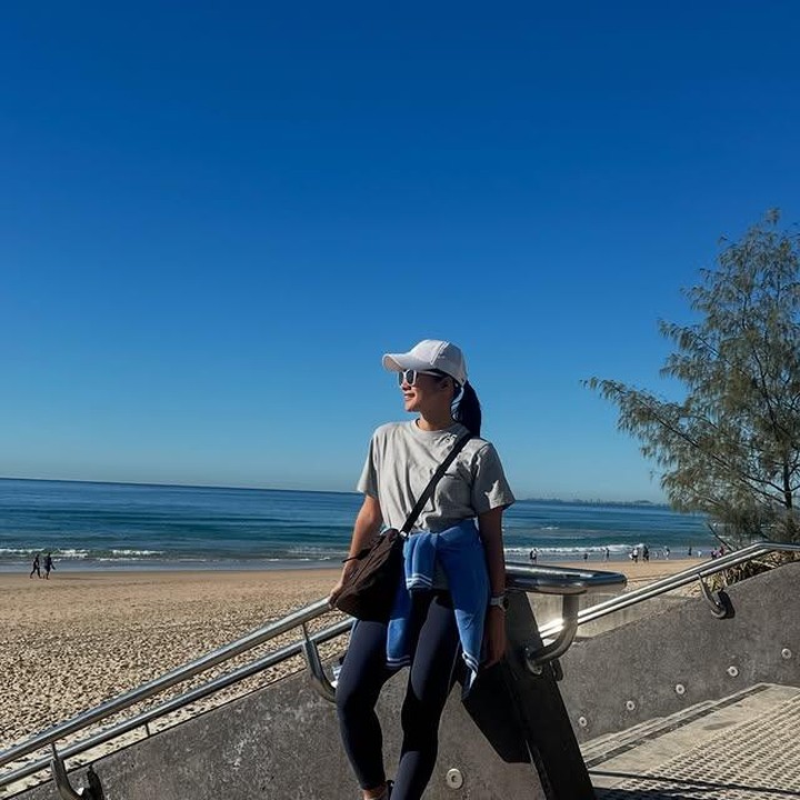 <p>Rini pun juga sudah mengeksplor keindahan pantai di Australia, Bunda. Ia tampak menikmati momen santai sambil tersenyum di bawah langit yang cerah. (Foto: Instagram @riniyulianti)</p>