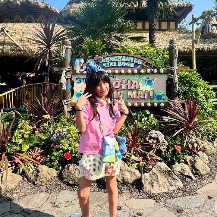 <p>Saat liburan seru ke Tokyo Disneyland, gaya Salma tak kalah keren. Ia tampil menggemaskan dengan bando karakter Stitch yang dipadukan dengan kaos <em>pink</em> dan rok rajut bergambar bintang laut. (Foto: Instagram @atiqahhasiholan)</p>