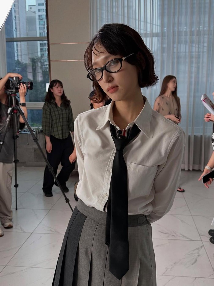 Terlihat klasik dan chic dengan kemeja putih yang ia padukan dengan rok A-line beraksen abu-abu, untuk mempermanis gayanya, Ryu Hye Young juga menambahkan dasi dan kacamata/ Foto: Instagram.com/ryuniverse328
