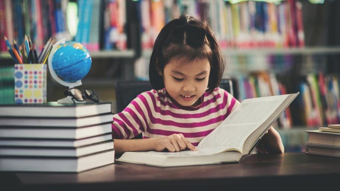 Portrait of a student child girl studying at library,Learning Concept