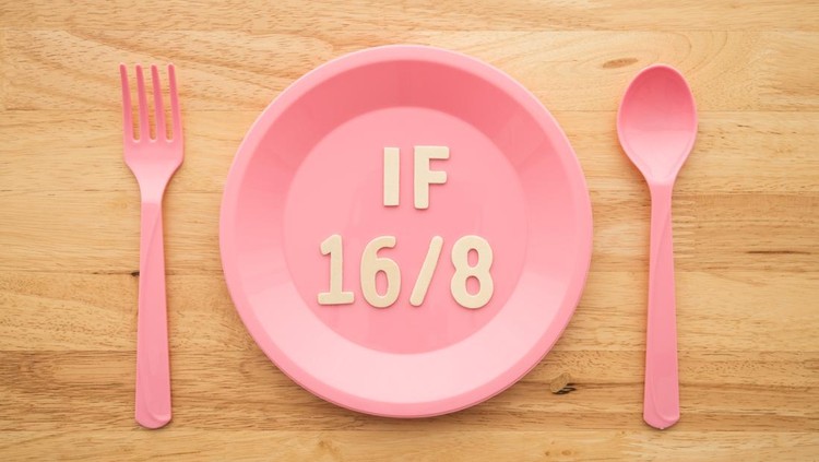 IF (Intermittent Fasting) 16 and 8 diet rule and weight loss concept. IF 16 and 8 letter on pink plate, spoon and fork on wooden table background.