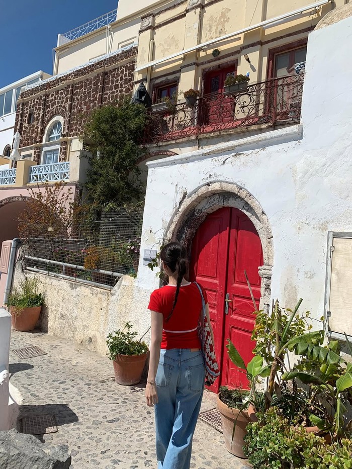 Jung So Min terus berupaya mengajak penggemar untuk mengikuti setiap langkahnya menyusuri rumah-rumah indah di desa Oia. Salah satunya adalah rumah berpintu merah yang senada dengan outfit sang aktris./ Foto: instagram.com/somin_jj