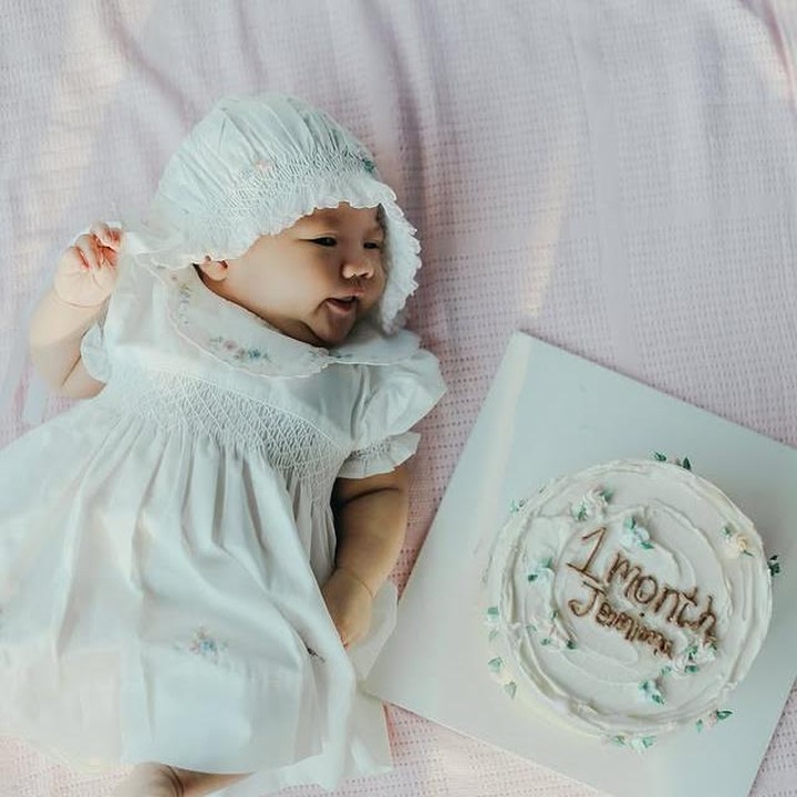 <p>Dalam unggahan perayaan usia 1 bulannya, sang Bunda membagikan potret Jemima yang tampak menggemaskan dengan <em>dress</em> putih dan penutup kepala yang serasi. Kue ulang bulan bertuliskan &ldquo;1 Bulan Jemima&rdquo; pun menjadi pelengkap di momen spesial ini. (Foto: Instagram @achasinaga)</p>