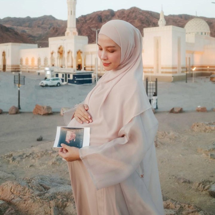 <p>Hamidah secara khusus mengungkap tentang momen kehamilan ketiganya. Ia mengucapkan terima kasih karena akhirnya bisa membangikan kabar ini ke publik. "Madina - mecca <em>for baby number 3</em>, banyak cerita yang pengen aku bagikan di kehamilan ketiga ini sama kalian, makasih yaaa yg udah jaga sampai aku bisa bagikan moment ini sama semuanya," tulisnya. (Foto: Instagram @defarhad/ @hamidahrachmayanti)</p>