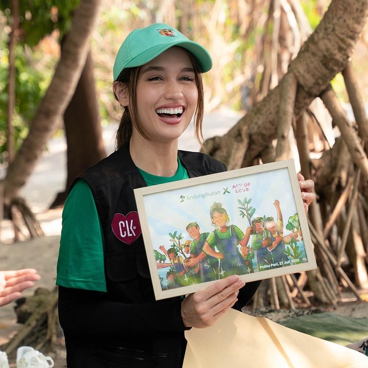 <p>Selama proses menanam mangrove, Cinta tak henti-hentinya menebar senyum. Perempuan keturunan Jerman ini bahkan sempat tersenyum saat melakukan interaksi dengan peserta lain yang ikut menanam mangrove, Bunda. (Foto: Instagram @claurakiehl)</p>