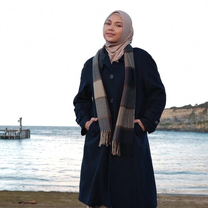 <p>Indah banyak menggunakan padu padan warna gelap dalam gaya busana hijabnya. Dalam satu penampilan, Bunda satu anak ini terlihat mengenakan jilbab dan rok berwarna cokelat muda, yang dipadukan dengan jaket hitam dan kain syal musim dingin berwarna senada. (Foto: Instagram @indahpermatas)</p>