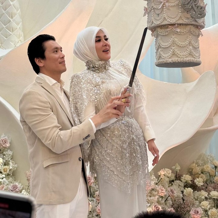 <p>Syahrini dan Reino Barack mengadakan pesta perayaan ulang tahun tertutup, yang hanya dihadiri oleh kerabat dan teman dekat. Di acara ini, Syahrini dan suami kompak mengenakan baju bernuansa warna putih gading menyesuaikan dengan tema pesta. Dalam satu momen yang dibagikan tamu undangan, Syahrini dan suami terlihat tengah memotong kue ulang tahun unik dan mewah yang tergantung dari atas. (Foto: Instagram @yunishara36)</p>
