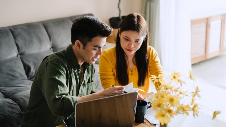 Ilustrasi pasangan suami istri Asian husband and wife planning family finances together at home.