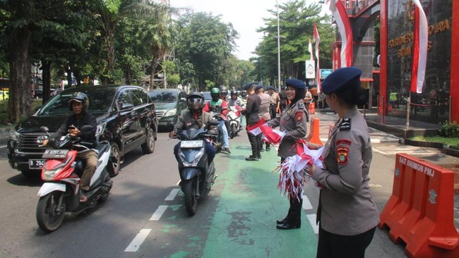 Dalam rangka HUT ke-80 RI, jajaran kepolisian di sejumlah wilayah Indonesia melakukan aksi simpatik bagi-bagi bendera Merah Putih kepada warga di jalanan.