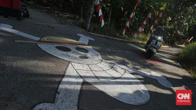 Sekelompok pemuda yang tergabung dalam Karang Taruna Wiryadarma melukis sebuah mural ala 'One Piece'. Mereka khawatir karya itu dihapus.