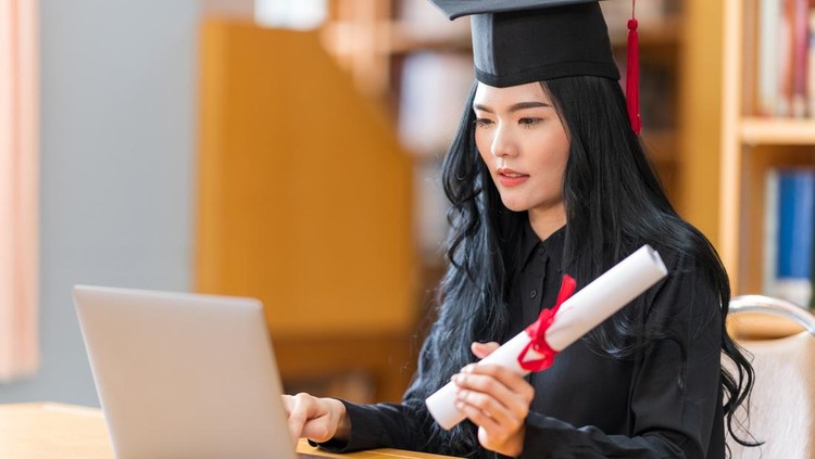 student is celebrating her graduation in a term  of social distancing by video conference on laptop computer.