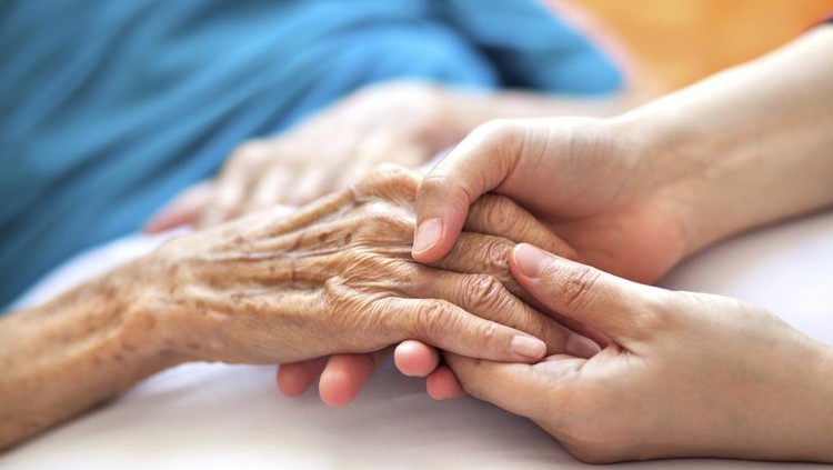 Ilustrasi lanjut usia Woman holding senior woman's hand on bed